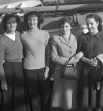 Women posed in front of ship