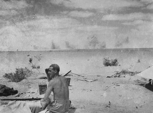 Shells bursting on the horizon at El Alamein