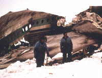 Plane wreckage with men in front