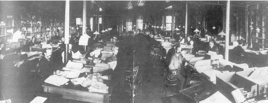 Men working at desks in large dark office