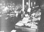 Row of men working in cramped office