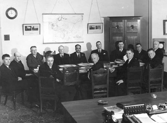 Photo of men grouped around table