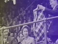 Man offering Queen a tartan blanket