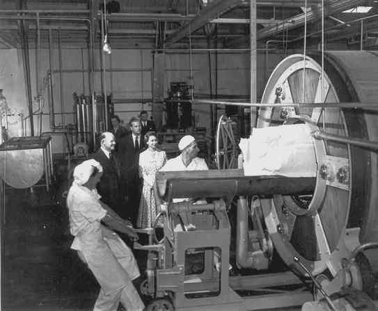 Quenn watches as med extract  butter emerge from large churn