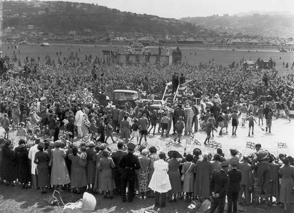 Crowds in park waving flags.