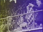 Man offering Queen a tartan blanket