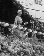 Queen speaking surrounded by flowers