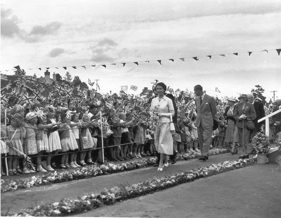 Children waving flags at the Queen and Prince