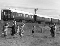 People in field waving at train