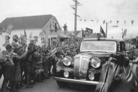 Car driving through cheering crowds